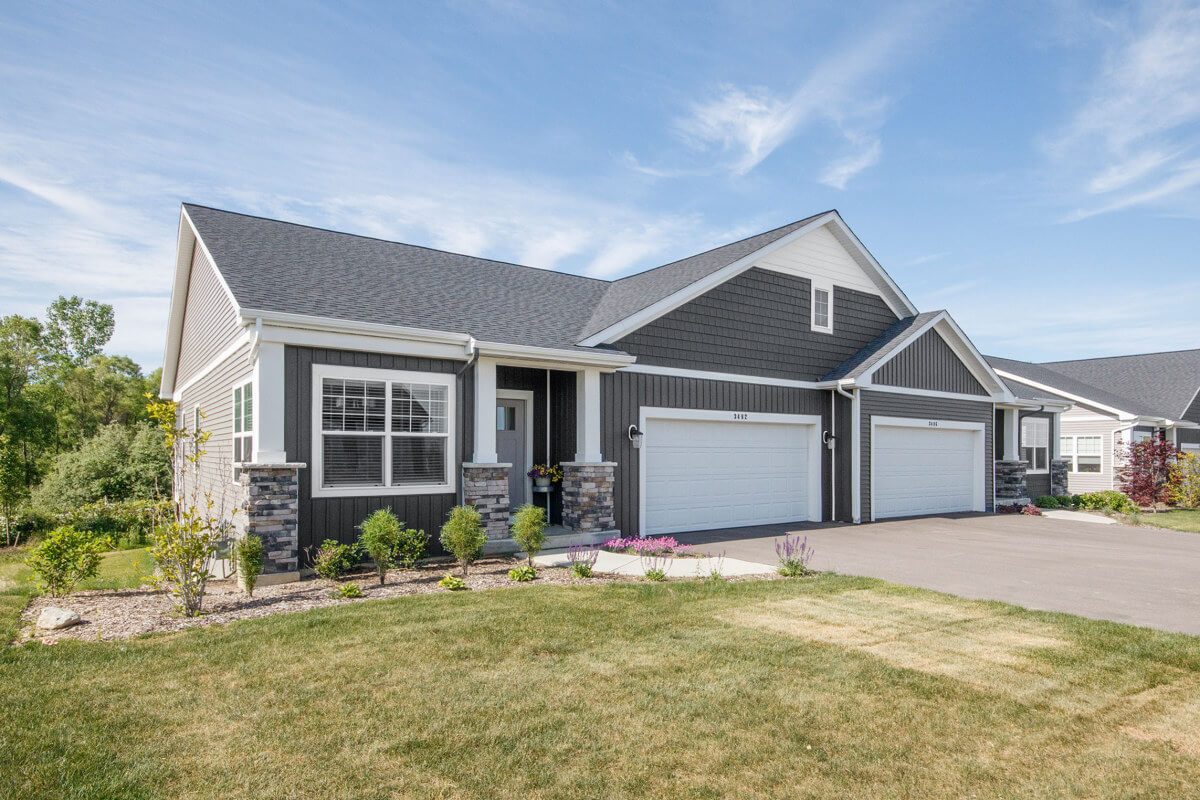An exterior photo of the Rivertown Vistas ranch style condos on a bright sunny day. This photo shows the duplex layout.